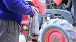 Farmer cleaning out tractor filter.