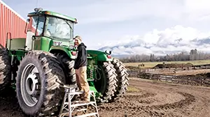 Farmer on machinery on farm.