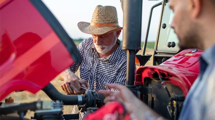 Two men working on a tractor engine