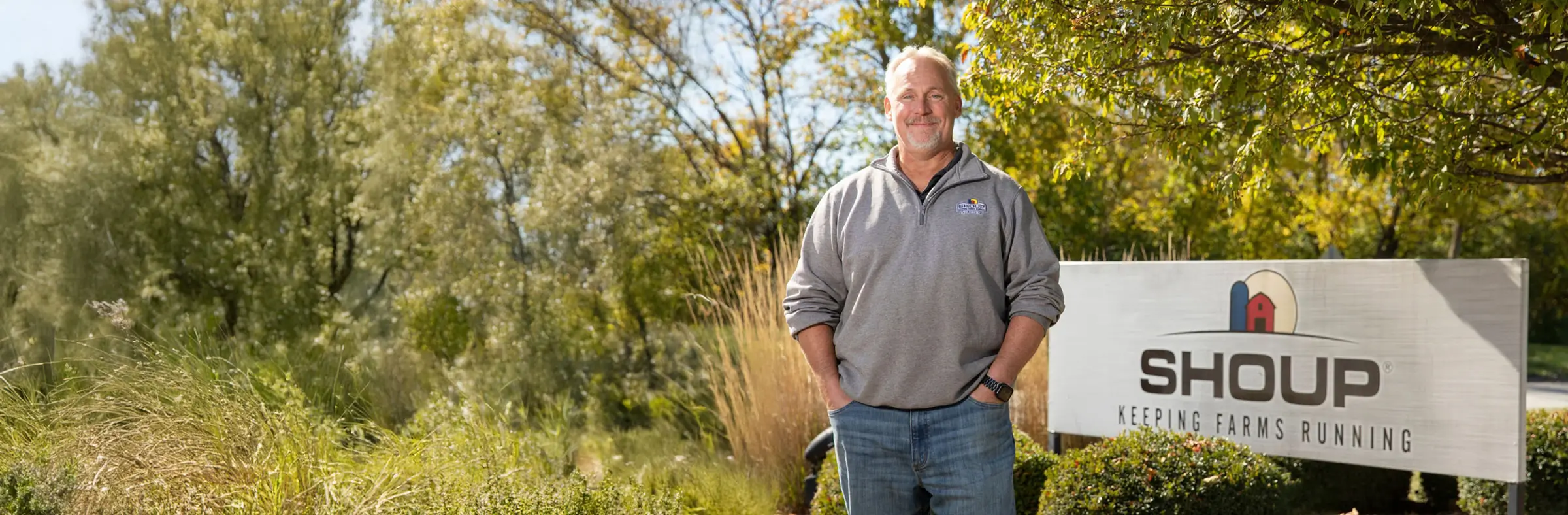 Man in field holding shoup boxes